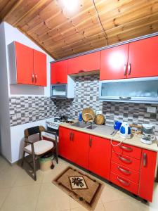 a kitchen with red cabinets and a stove top oven at LATE Nature House Gjirokaster in Gjirokastër