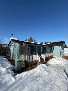 a house in the snow with a trash can next to it at Rauhan pesä in Karigasniemi