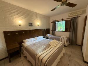 a bedroom with two beds and a ceiling fan at Villa de Merlo All Inclusive & Spa by MH in Merlo