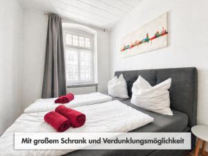 ein Schlafzimmer mit zwei Betten und einer Couch mit roten Kissen in der Unterkunft Comfycation Gera in Gera