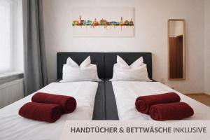 zwei Betten mit roten Kissen in einem Zimmer in der Unterkunft Comfycation Gera in Gera