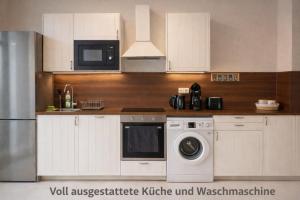 eine Küche mit Waschmaschine und Mikrowelle in der Unterkunft Comfycation Gera in Gera