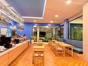 a restaurant with tables and chairs and a counter at Golden Paradise Hotel - SHA PLUS in Karon Beach