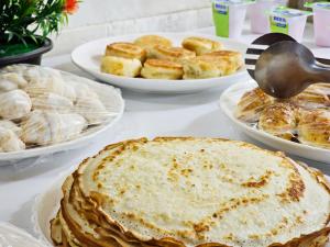 a table topped with plates of pies and pastries at Amir Mumtoz Hotel in Bukhara +15 photos