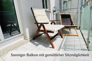 ein Schaukelstuhl auf einem Balkon neben einem Fenster in der Unterkunft Comfycation Gera in Gera + 10 Fotos