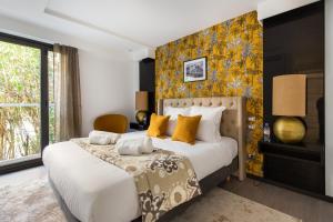 a bedroom with a large bed with yellow pillows at Villa Alexandra by Sweett in Cannes +29 photos