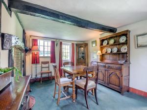 a dining room with a wooden table and chairs at Glebe Cottage in Powick