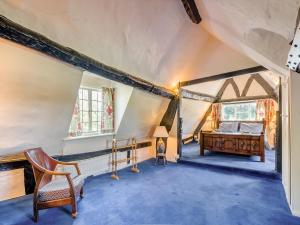 an attic room with a bed and a chair at Glebe Cottage in Powick +15 photos