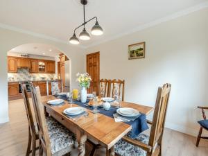 a kitchen and dining room with a wooden table and chairs at Melancroft in Llanfihangel-nant-Melan