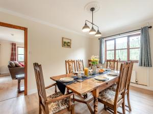 a dining room with a wooden table and chairs at Melancroft in Llanfihangel-nant-Melan