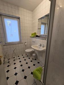 a bathroom with a sink toilet and a mirror at Pension Reuss - Hotel garni in Erfurt