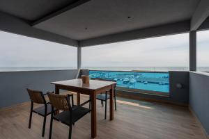 Ein Tisch und Stühle in einem Zimmer mit Meerblick in der Unterkunft Poseidon Girni Sea View Apartments in Paralia Katerinis