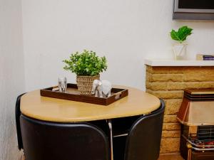a wooden table with a plant and a vase on it at St Mary's Crescent House in Stanwell