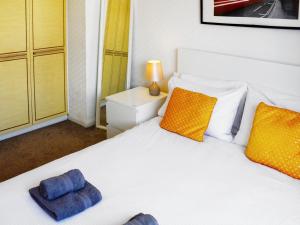 a bedroom with a white bed with two pillows on it at St Mary's Crescent House in Stanwell +4 photos