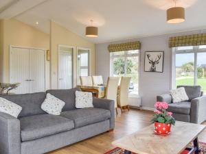a living room with a couch and a table at Buckland Lodge in Pentridge