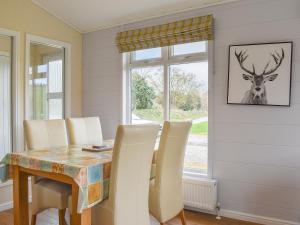 a dining room with a table and a deer picture on the wall at Buckland Lodge in Pentridge