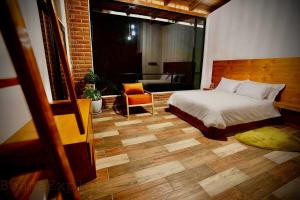 a bedroom with a bed and a chair in a room at Boana Explora Pachijal in Pedro Vicente Maldonado