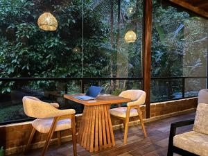 a wooden table with chairs and a laptop on it at Boana Explora Pachijal in Pedro Vicente Maldonado +33 photos