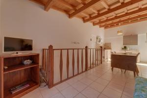 a living room with a television and a kitchen at Il Boschetto sul Mare - Goelba in Capoliveri