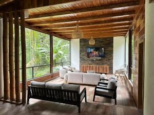 a living room with a couch and a tv at Boana Explora Pachijal in Pedro Vicente Maldonado