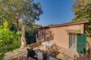 a house with a table and chairs on a patio at Il Boschetto sul Mare - Goelba in Capoliveri