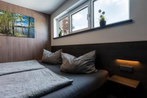 a bedroom with a bed with pillows and a window at Ferienhaus SUNSHINE am Mühlfeldsee in Löbnitz