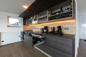 a kitchen with a black counter top and a stove at Ferienhaus SUNSHINE am Mühlfeldsee in Löbnitz