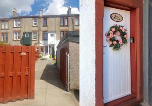 a white door with a wreath on it next to a building at Saphire Apartments Spacious 1 Bed Apartment Sleeps 6 with Free Parking and Garden in Giffnock