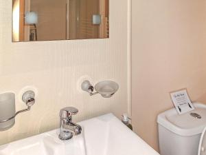 a bathroom with a sink and a mirror and a toilet at Forrest Lodge in Plumbland +3 photos