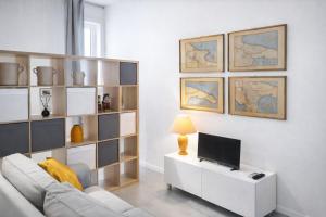 a living room with a white couch and a television at casAlitti in Bitonto