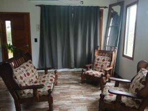 a living room with two chairs and a window at Cabaña la Monita in Tandil