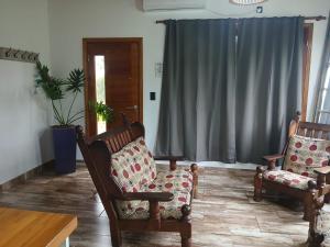 a living room with two chairs and a table at Cabaña la Monita in Tandil