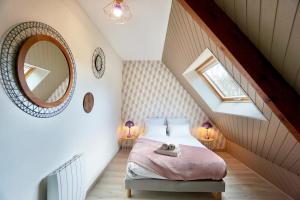 a attic bedroom with a bed and a mirror at La Parenthèse -piscine in Ploemeur +62 photos
