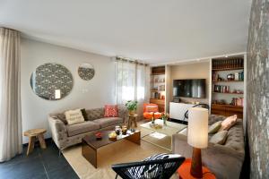 a living room with a couch and a table at La Parenthèse -piscine in Ploemeur