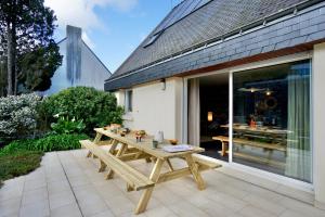 a picnic table on the patio of a house at La Parenthèse -piscine in Ploemeur