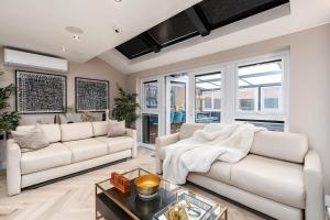 a living room with two white couches and windows at Riverside Villas in Manchester