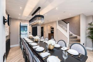 a dining room with a long table and chairs at Riverside Villas in Manchester