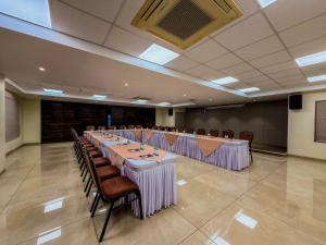 a large banquet hall with long tables and chairs at Zip By Spree Hotels Kolhapur in Kolhapur