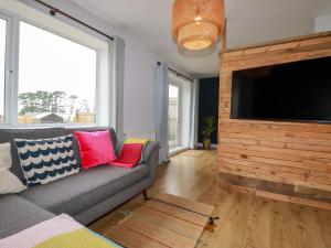 a living room with a couch and a flat screen tv at Trelowen in Wadebridge
