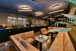 a restaurant with couches and tables and a bar at Hotel ZOE by AMANO in Berlin