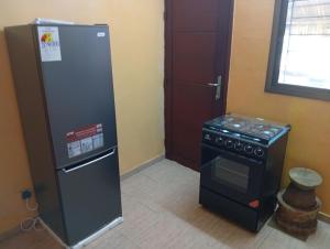 a kitchen with a refrigerator and a stove at Johannys'co in Abidjan