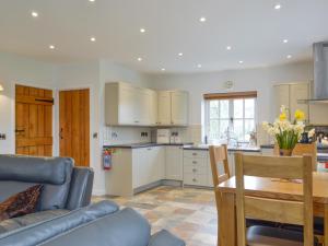 a kitchen and living room with a couch and a table at Gelli Hir in Bronant