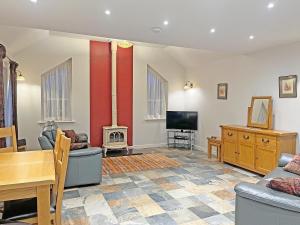 a living room with a fireplace and a tv at Gelli Hir in Bronant