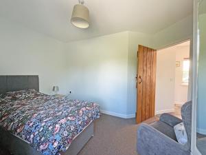 a bedroom with a bed and a chair at Gelli Hir in Bronant +7 photos