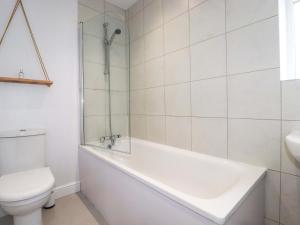 a white bathroom with a tub and a toilet at Trelowen in Wadebridge +22 photos