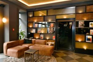 a living room with a brown couch and a table at Hotel ZOE by AMANO in Berlin