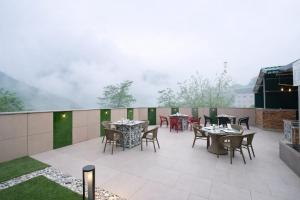 a patio with tables and chairs on a balcony at Hotel LA Eden in Mussoorie