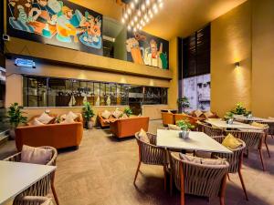 a restaurant with tables and couches and chairs at Zip By Spree Hotels Kolhapur in Kolhapur