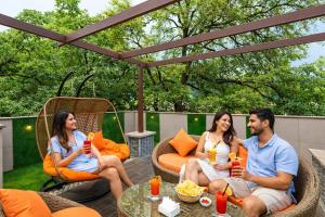 a group of people sitting on a patio with drinks at Hotel LA Eden in Mussoorie