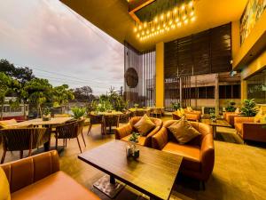 a living room with couches and tables and chairs at Zip By Spree Hotels Kolhapur in Kolhapur